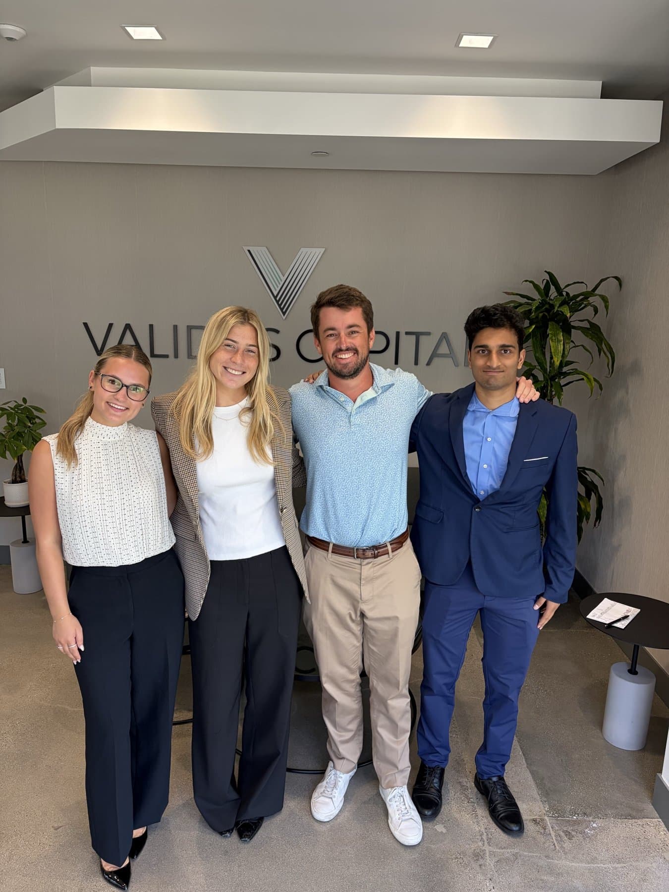 Avery Zenz with members of the Validus Capital team in front of the firm's sign